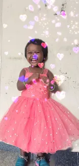 Smiling child in pink dress with glowing hearts background.