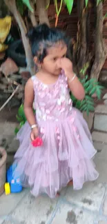 Young girl in pink dress with garden background.