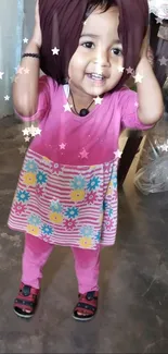 Smiling child in pink outfit with stars