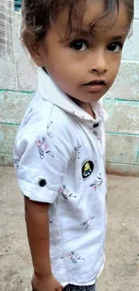 Image of an adorable child in white shirt standing.