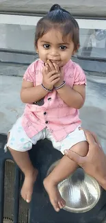 Adorable child with a bright smile sitting on a vintage vehicle.