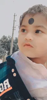 Adorable child in a blue jacket outdoors.