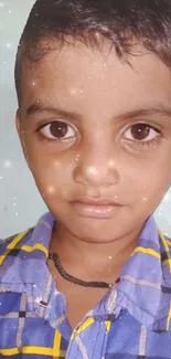 Adorable child with sparkling eyes in a light blue-themed portrait.