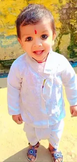 Smiling child in traditional outfit outdoors.