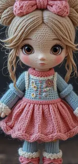 Adorable crochet doll in pink and blue outfit with bow.