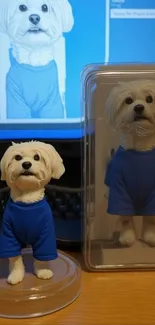 Cute dog figurine in blue shirt displayed on desk.