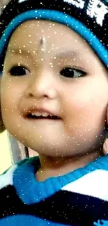 Cute child in a blue winter hat smiling warmly.