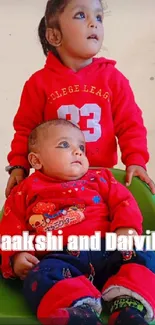 Two adorable children in red outfits, one sitting in a green seat.