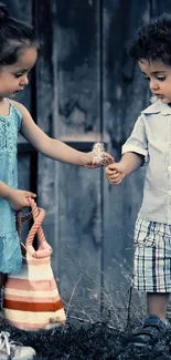 Two children sharing a sweet moment outdoors by a wooden fence.