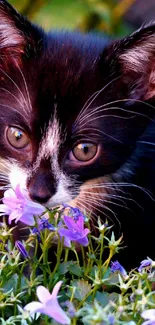 Adorable kitten sniffing purple flowers in a vibrant garden setting.