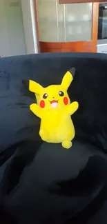 Pikachu plush on a blue chair with kitchen background.