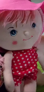 A cute plush doll with pink hat and polka dot dress.