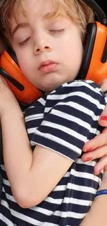 Child sleeping with headphones and striped shirt.