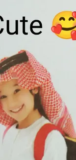 Adorable child smiling with heart emoji and traditional headscarf.