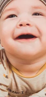 Adorable baby with a striped hat and a joyful smile.