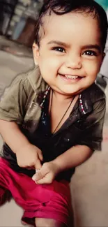 Cute baby with a big smile wearing pink shorts.