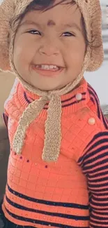 Smiling child in cozy orange sweater and hat