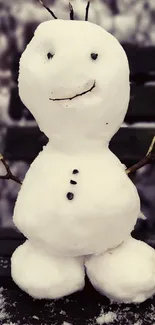 Cute snowman standing on a snowy bench in winter.