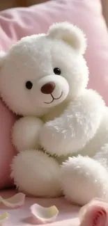 Adorable white teddy bear on a pink cushion with petals.