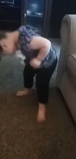 Adorable toddler standing on carpet next to sofa, exploring her surroundings.