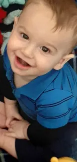 Adorable toddler wearing a blue outfit with a joyful expression.