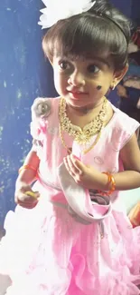 Adorable toddler in a pink dress smiling brightly.