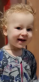 Adorable curly-haired toddler smiling brightly