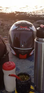 Helmet and gear by the coast at sunset.