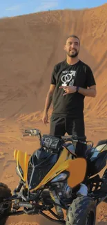 Person riding yellow ATV on sandy dunes.