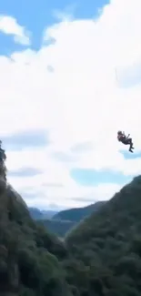 Person ziplining over green hills with a blue sky backdrop.