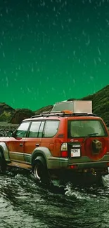 Red Jeep crossing river in rainy green landscape.