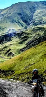 Motorcyclist on a scenic mountain path over lush green hills.