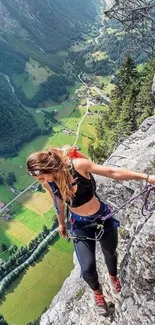 Woman rock climbing on a steep mountain with a valley view.