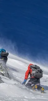 Mountain climbers ascending a snowy peak under a clear blue sky.