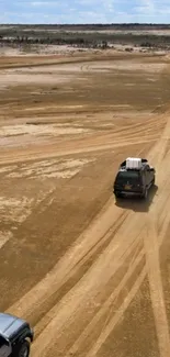 Three vehicles drive through a vast desert landscape.