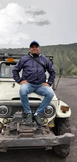 Person sitting on jeep in striking mountain scenery.