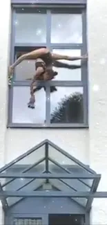 Acrobat performing stunts on a building wall with urban background.