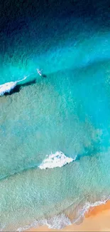 Aerial view of beach with blue waves and sandy shore.