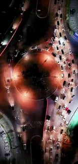 Aerial view of a vibrant city roundabout at night with flowing traffic.