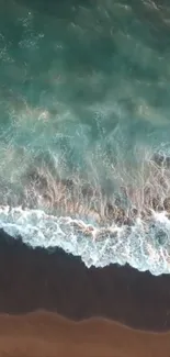 Aerial view of ocean waves meeting sandy beach.