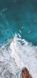 Aerial view of ocean waves with surfers, perfect for mobile wallpaper.