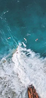 Aerial view of ocean waves with surfers, showcasing vibrant blue and white textures.