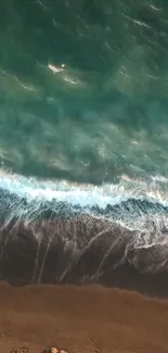 Aerial view of ocean waves meeting sandy beach on a mobile wallpaper.