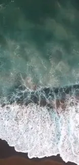 Aerial view of ocean waves crashing on a sandy beach.