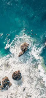 Aerial view of ocean waves crashing on rocky shore.