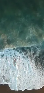 Aerial view of ocean waves crashing onto a sandy beach.