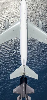 Aerial view of military aircraft refueling above the ocean.