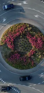 Aerial view of a floral roundabout with cars and road design.