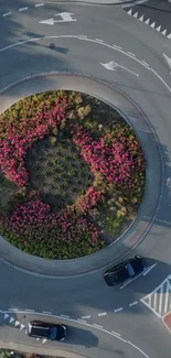 Aerial view of a roundabout with pink flowers in the center.