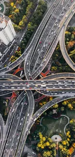 Aerial view of a busy city highway intersection surrounded by greenery.